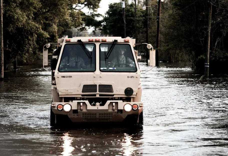 Oshkosh Defense FMTV driving on a flooded road.