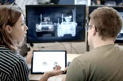 Oshkosh Defense engineers looking at a computer screen.