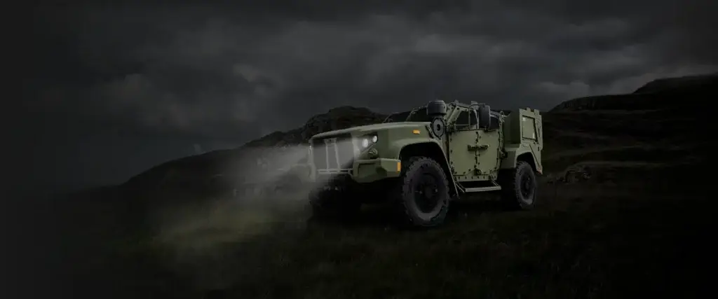 Oshkosh Defense eJLTV on a hillside at night.
