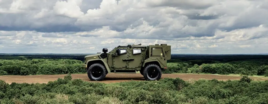 Oshkosh Defense eJLTV hybrid electric joint light tactical vehicle on a hilltop.